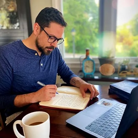M. Sage Gormley writing at a desk